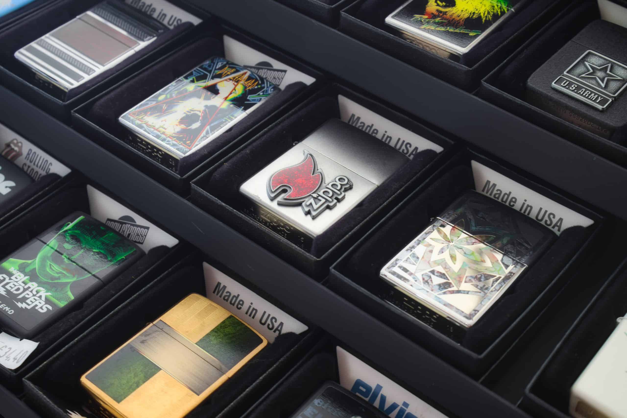 A collection of Zippo brand lighters in a retail display case