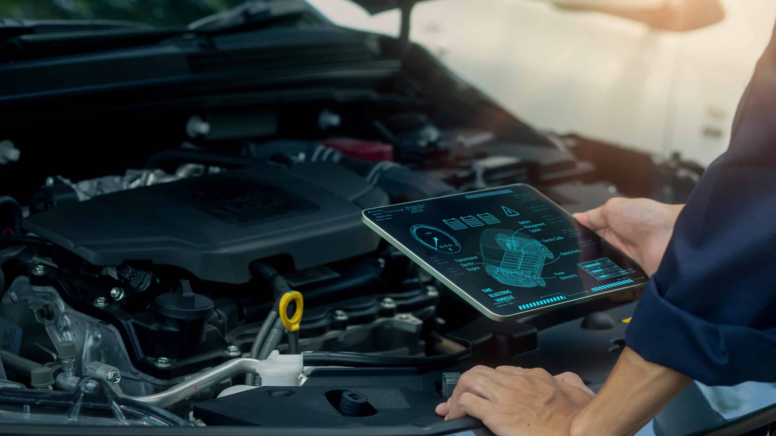 A technician uses a digital tablet to analyze engine data and monitor automotive performance with advanced diagnostic technology. Ideal for smart maintenance, modern vehicle inspection, and automotive engineering content.